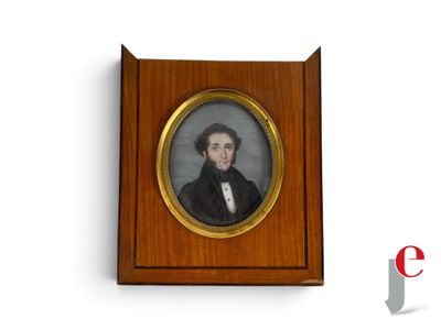 portrait d'un homme vêtu d'un manteau noir et d'une chemise blanche, dans un cadre en bois