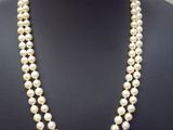 deux rangs de perles blanches avec un fermoir en or sur un mannequin noir