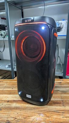 une enceinte posée sur une table en bois