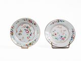 paire d'assiettes en porcelaine ornées de motifs floraux, présentées sur un présentoir