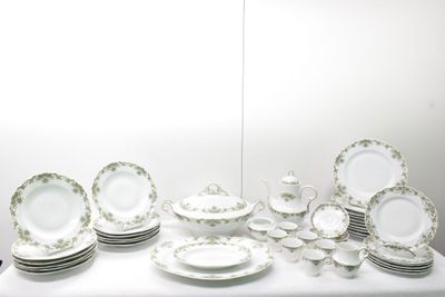 une table sur laquelle se trouvent beaucoup d'assiettes et de bols