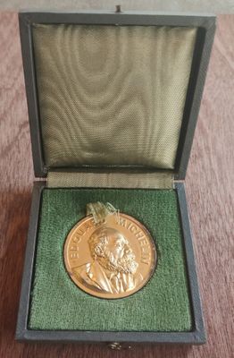 une photo d'une médaille d'or posée dans une boîte sur une table