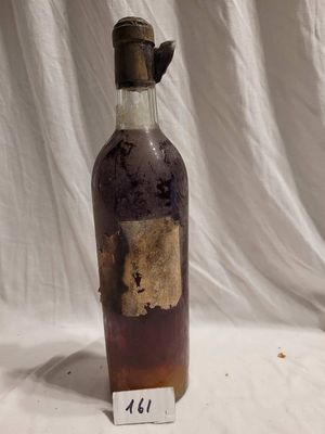 une vieille bouteille avec une étiquette, posée sur une table