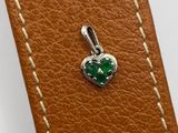 a close up of a brown leather case with a green heart charm
