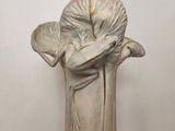 a white vase with a flower on it on a table