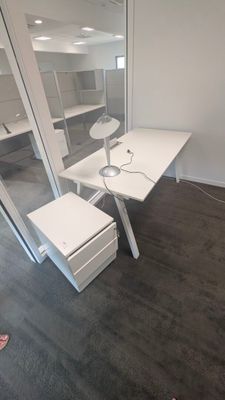 une photo d'une pièce avec un bureau et un miroir