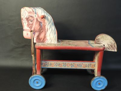 a wooden toy horse that is sitting on a black surface