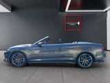 a blue convertible car parked inside of a building with a red sign above it
