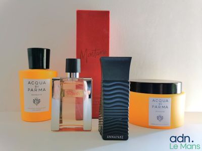 an assortment of perfumes are displayed on a white surface