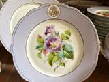 many plates with flowers on them on a table