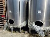 deux cuves en acier inoxydable placées côte à côte devant un bâtiment