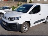 une camionnette blanche garée dans un parking à côté d'autres voitures
