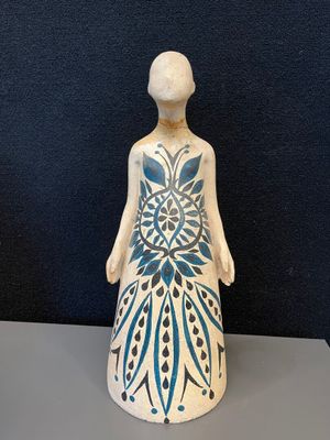 figurine en céramique représentant une femme dont le corps est orné d'un motif bleu et blanc