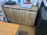 a desk with a printer and a file cabinet in the corner