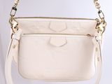 a white purse with a gold chain hanging from it ' s shoulder