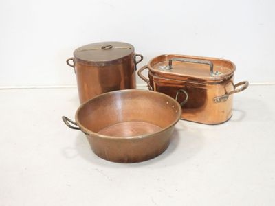 three copper pots and pans sitting on a table