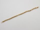 a gold bracelet with a chain on a white background
