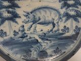 a blue and white plate with a picture of a boar on it