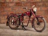 a red motorcycle that is parked in front of a brick wall