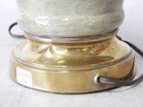 a silver and gold lamp that is on a white table