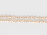 a close up of a row of pearls on a white surface