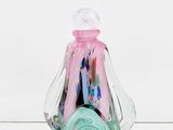 a glass vase with a pink and green liquid inside