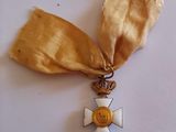 a gold medal with a cross on it on a white surface