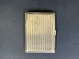 a small square metal object on a black surface