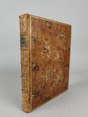 an old book sitting on top of a white table next to a white wall