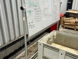 un tableau blanc accroché au mur, à côté d'une caisse en bois