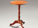 une petite table en bois avec un plateau en bois posé sur une surface blanche