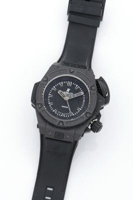 the watch is black and has a black rubber band