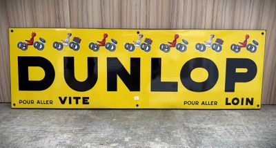 yellow and black dunlop sign on concrete floor next to wall