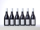 six bottles of wine are lined up on a table
