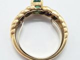 an image of a close up of a gold ring with a green stone