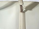 a close up of a white bag with a brown handle