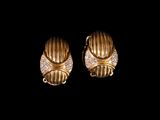a pair of gold and diamond earrings on a black background