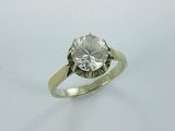a close up of a diamond ring on a white surface