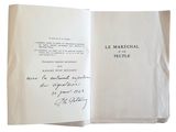 un livre ouvert, sur lequel figure un titre écrit à la main, posé sur une table