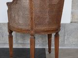 a wicker chair that is sitting on a black and white checkered floor