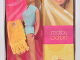 La poupée Barbie se trouve dans une boîte avec un sac à main jaune.
