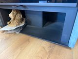 a dog that is sitting in the corner of a tv