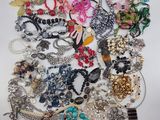 a pile of assorted jewelry on a white surface