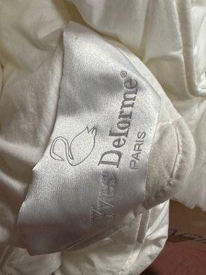 a close up of a bed with a pillow and a pillow cover