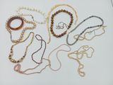 several necklaces and bracelets are arranged on a white surface