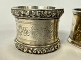two silver cups sitting next to each other on a table