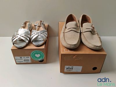 deux paires de chaussures de bébé posées sur une boîte en carton