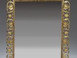 an ornately decorated mirror with a gold frame on a stand