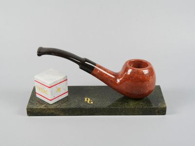une image représentant une pipe et une pile de livres posés sur une table