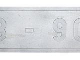 un gros plan d'une plaque métallique sur laquelle figure un numéro
